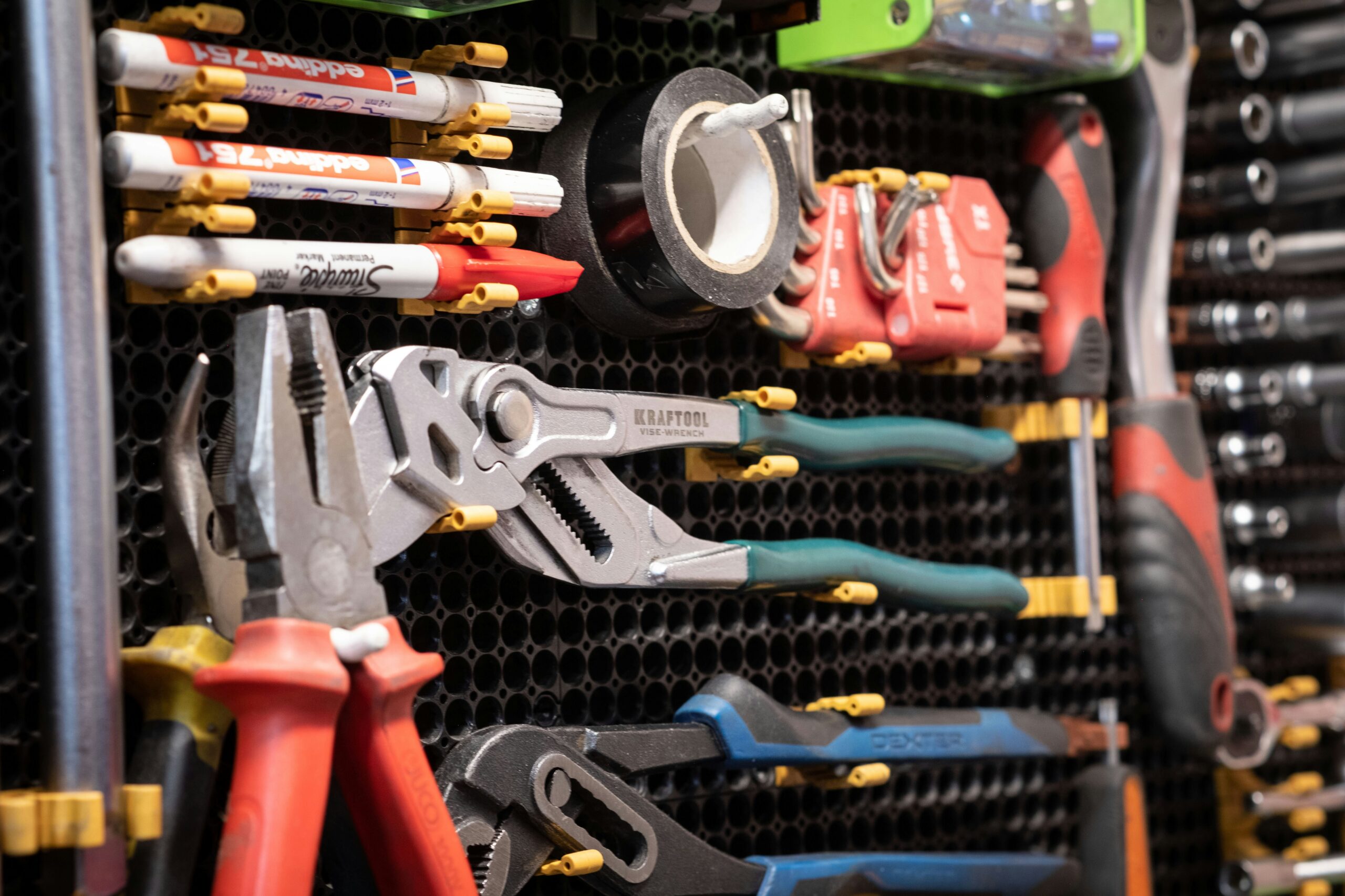 A bunch of tools are hanging on a rack