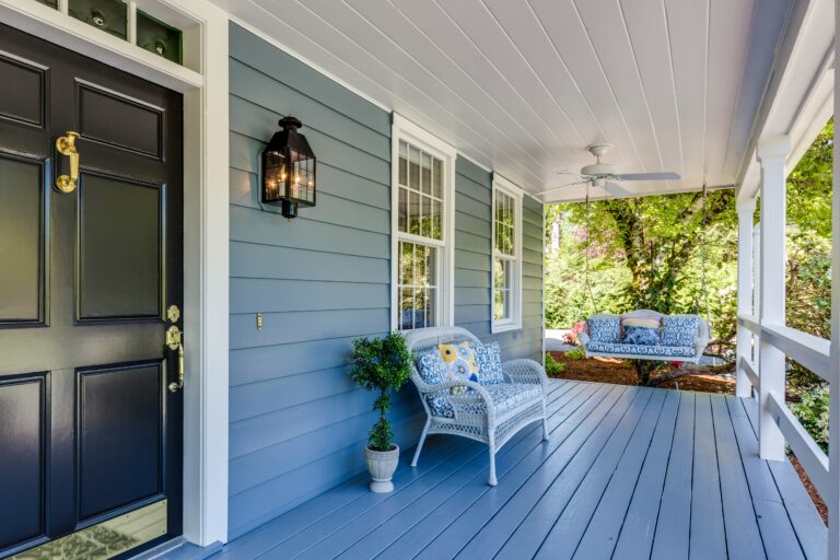 A porch with two chairs and a table on it - DIY Guide to Weatherproofing Your Front Door