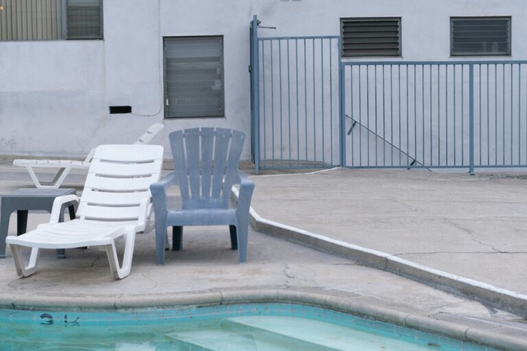 Chairs beside a swimming pool with a fence - How to Restore Faded Patio Furniture