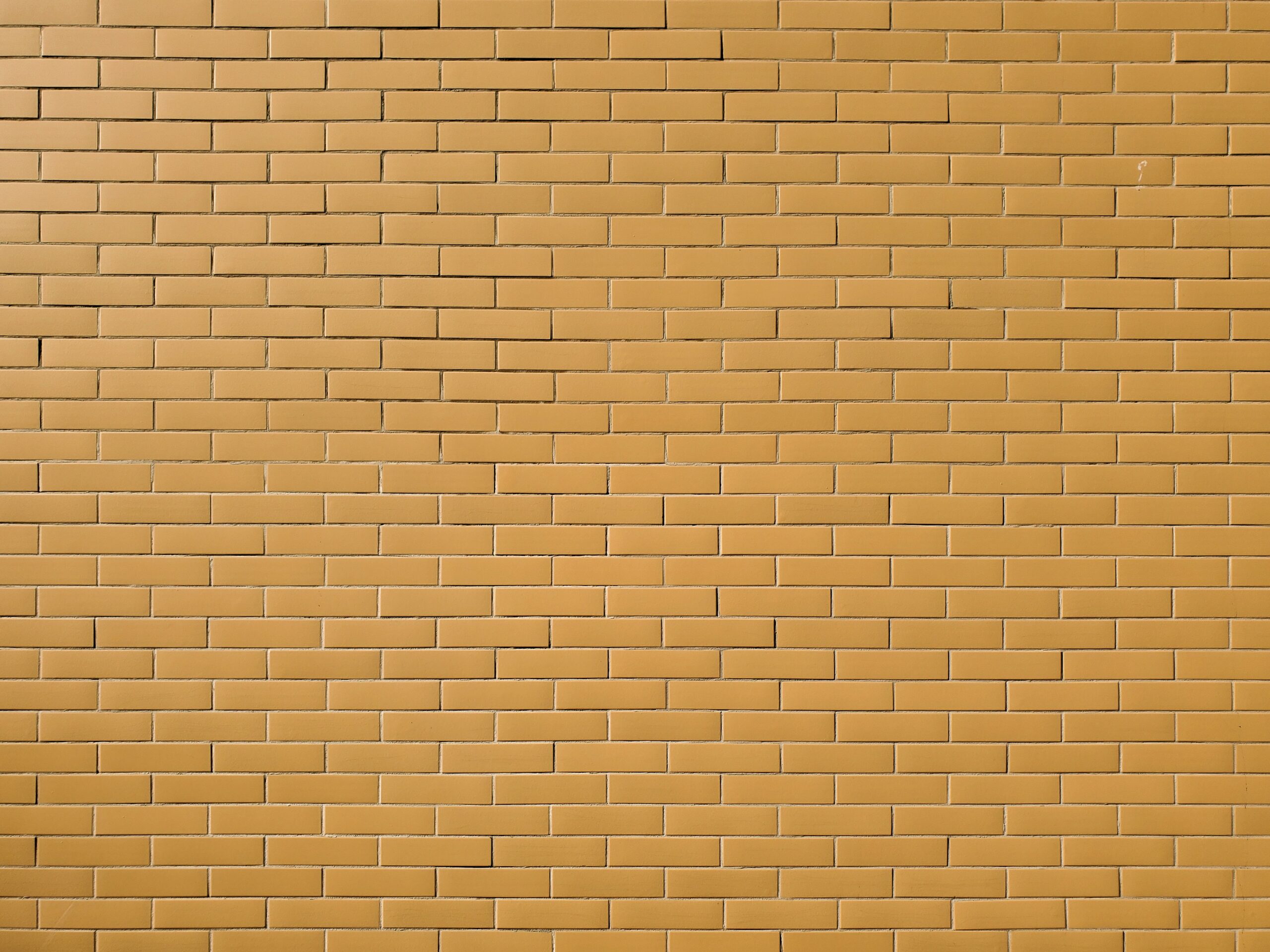 a yellow brick wall with a red stop sign