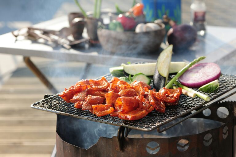 a bbq grill with vegetables and meat on it