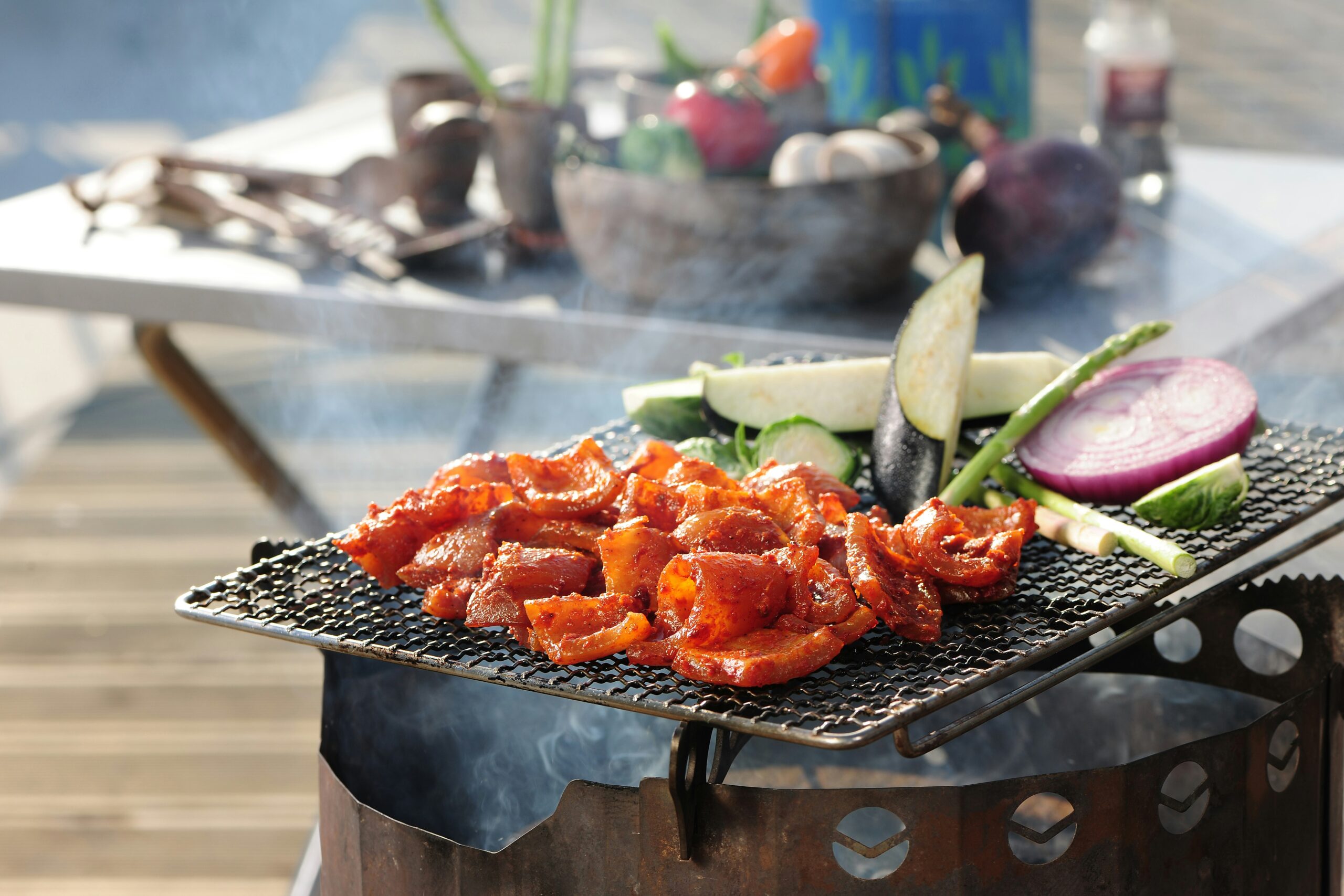 a bbq grill with vegetables and meat on it