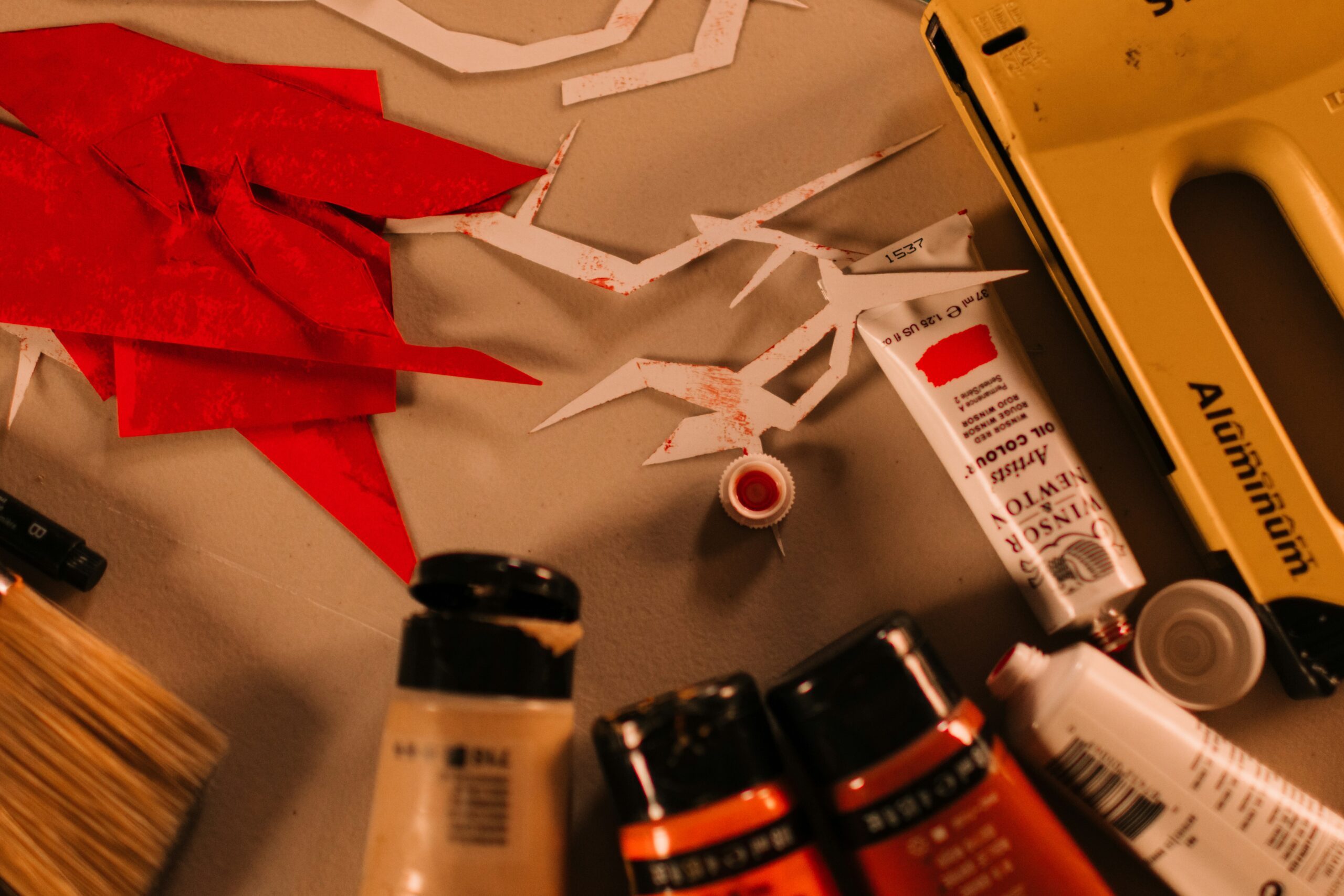 Art supplies with red and white paper cutouts
