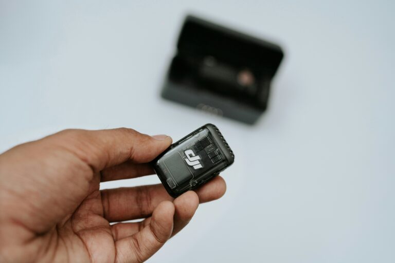 A hand is holding a black dji device.