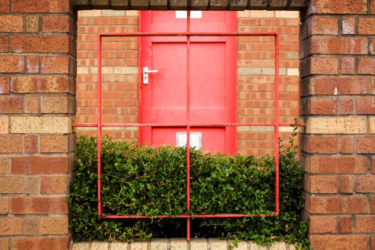red wooden door on brown brick wall