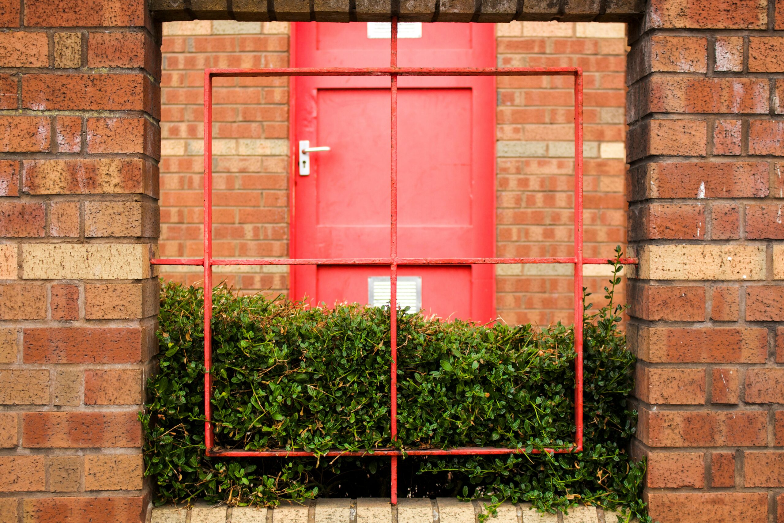 red wooden door on brown brick wall