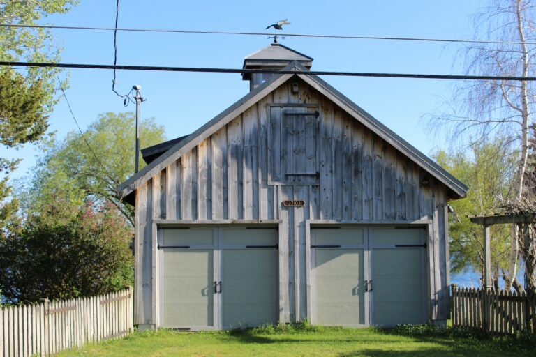 a wooden building with two doors and a steeple