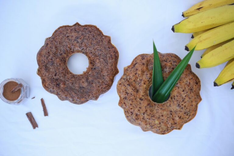 A table topped with two donuts and bananas