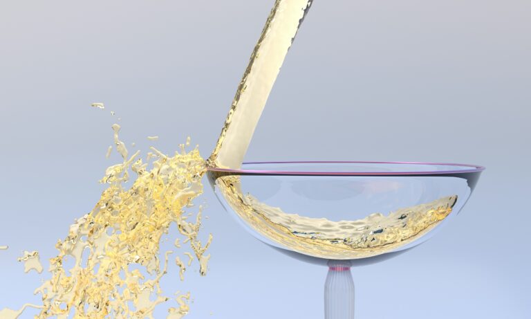 A glass of white wine being poured into it